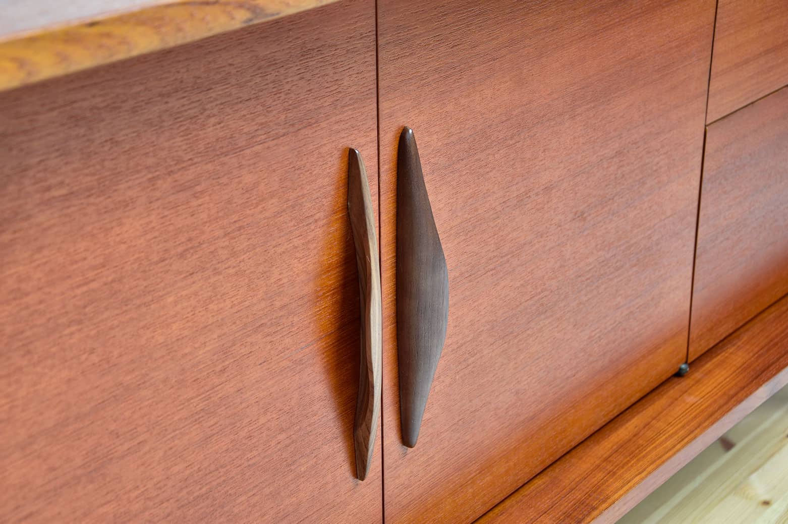 Enfilade scandinave vintage en teck avec poignées élégantes en bois foncé.