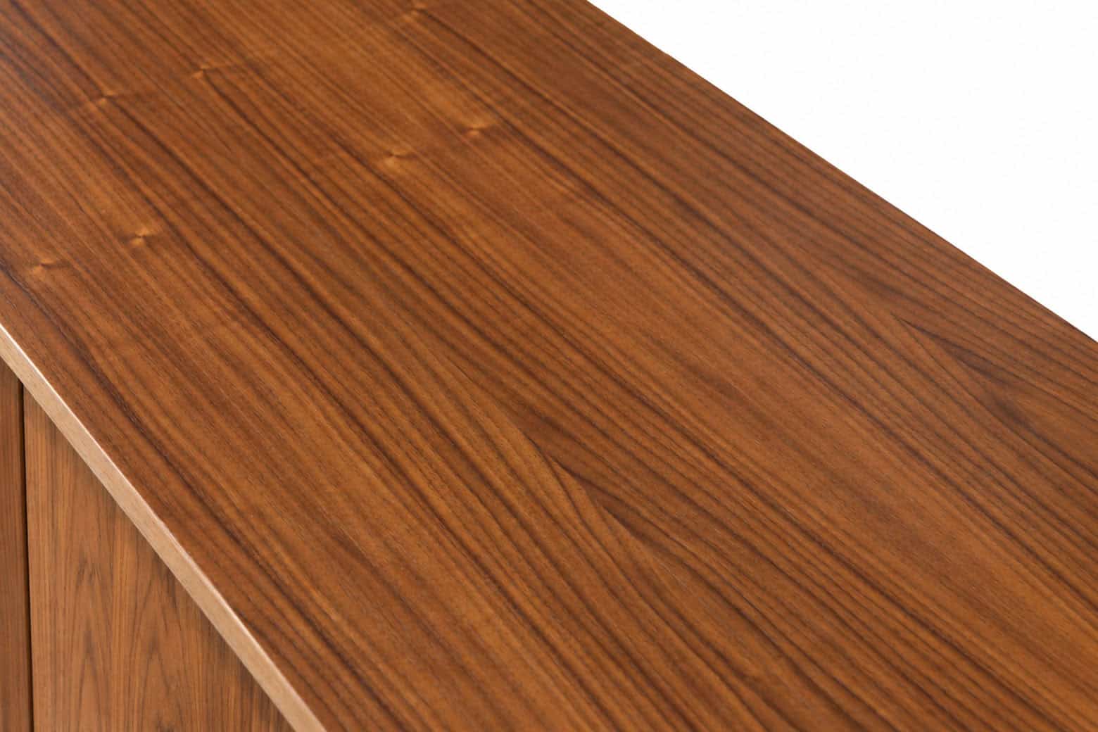 Détail d'une enfilade en noyer vintage restaurée, mettant en valeur la finition en bois naturel et la texture du noyer.