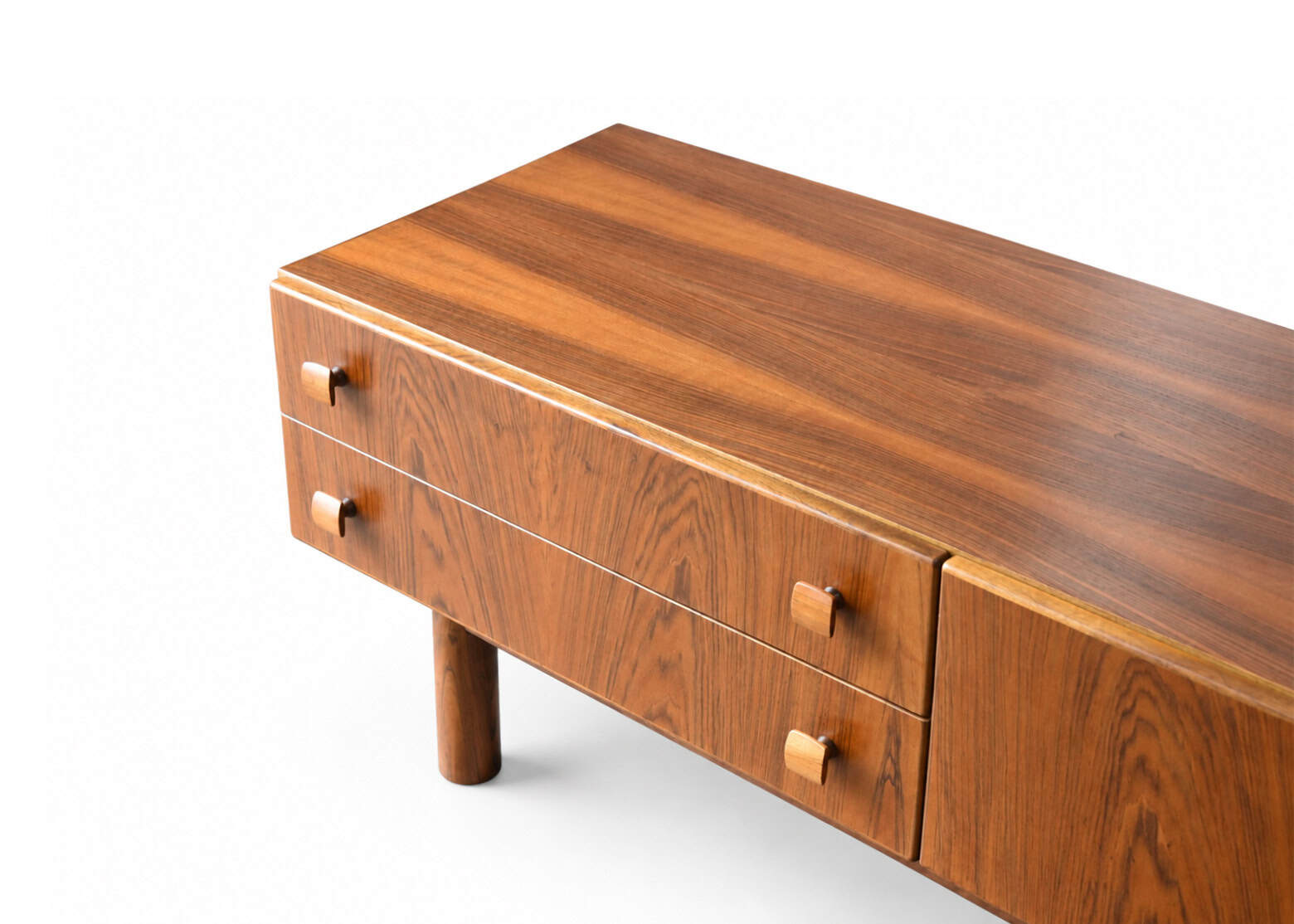 Enfilade basse scandinave vintage en bois de noyer avec tiroirs et pieds cylindriques, style rétro, meuble de rangement élégant.