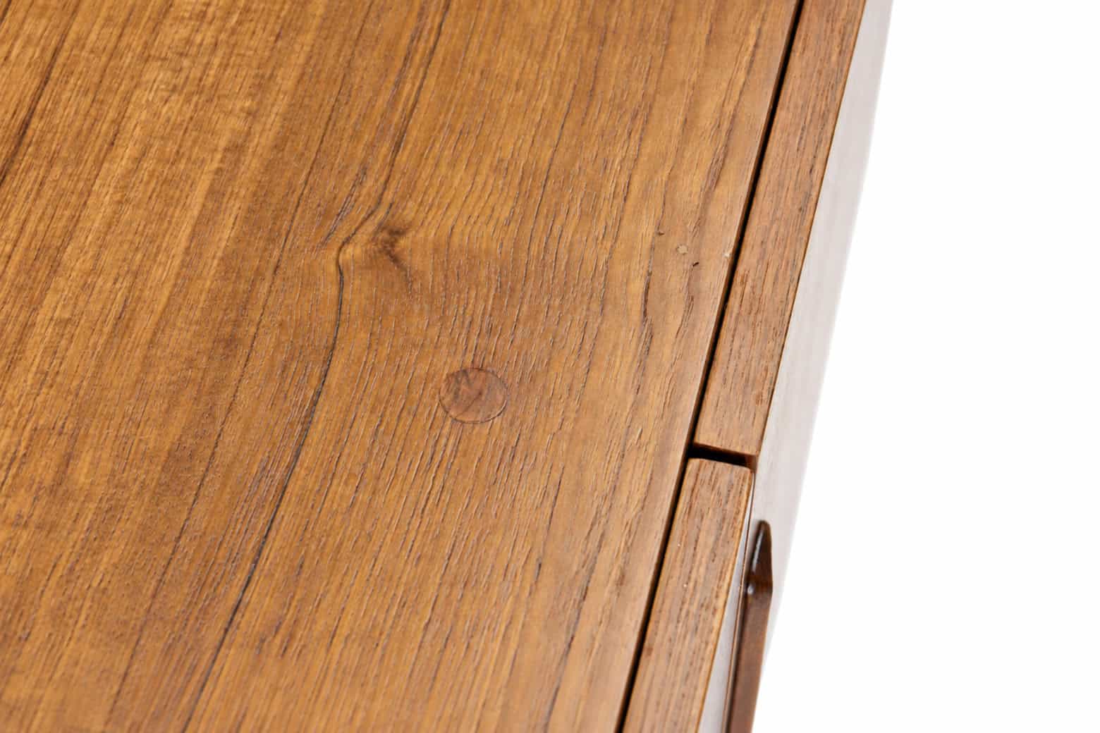 Détail d'une enfilade scandinave vintage en teck, mettant en valeur la texture et la finition du bois.