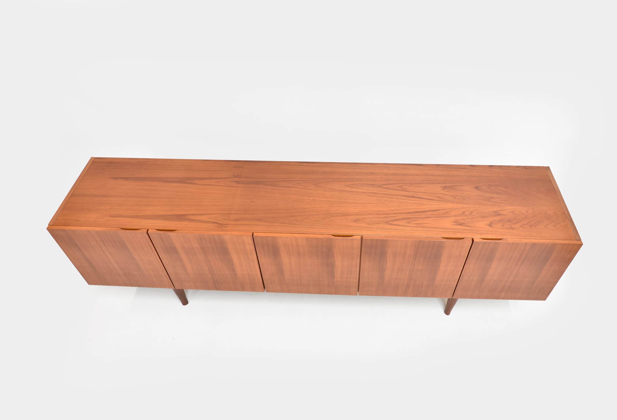 Enfilade scandinave vintage en teck restaurée, mettant en valeur le design épuré et la finition en bois de teck naturel. Parfaite pour un intérieur rétro ou contemporain.