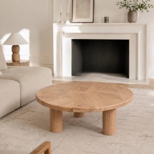 Table basse en bois massif dans un intérieur contemporain avec cheminée et décoration minimaliste.