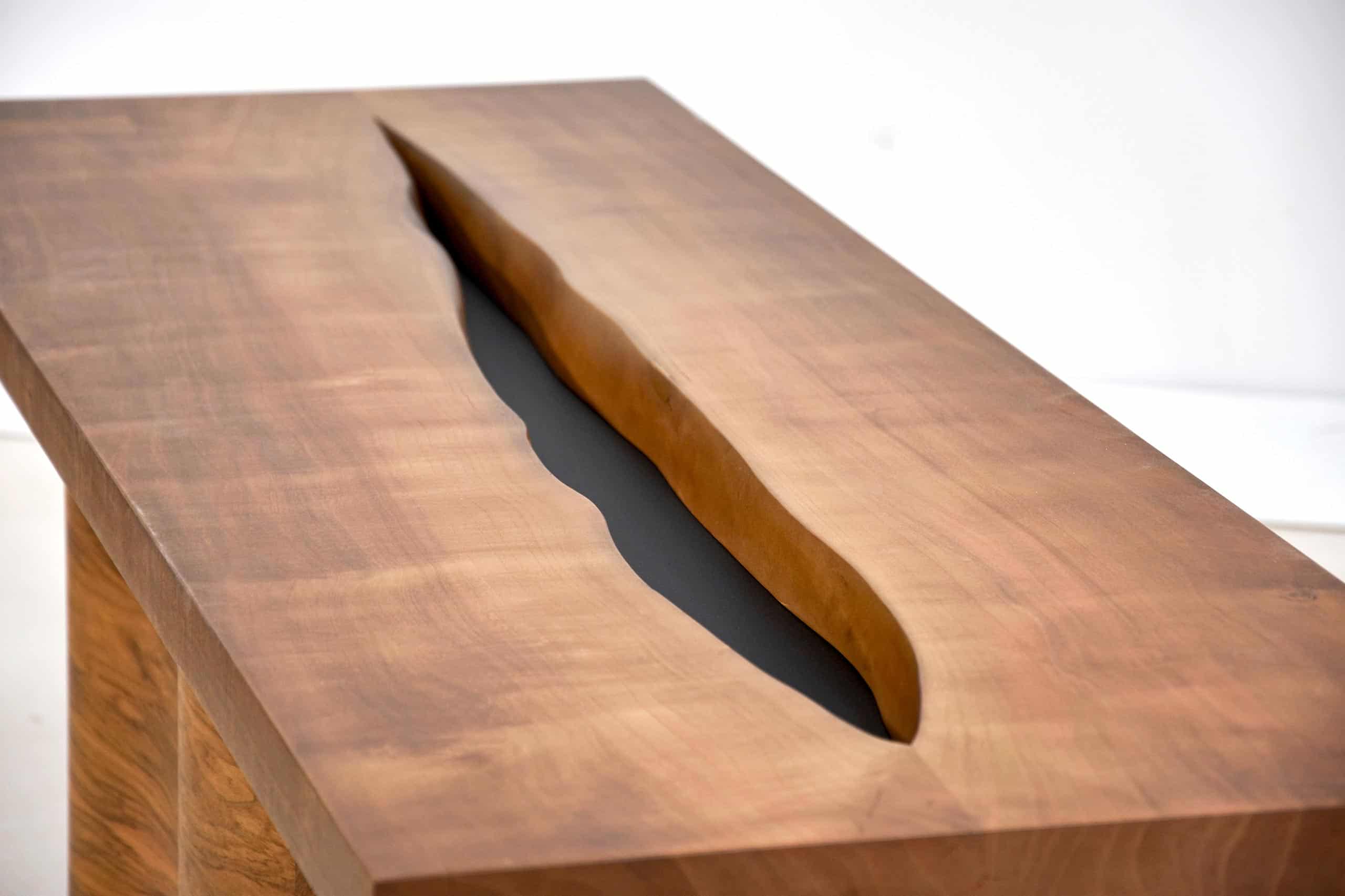 Une table en bois massif avec une rainure centrale, mettant en valeur le travail artisanal et la finition naturelle du bois.