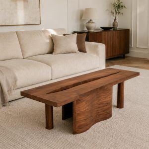 Table basse en bois naturel dans un salon contemporain avec canapé beige, décor minimaliste et ambiance cosy.