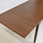 Table à rallonge vintage en teck, idéale pour salle à manger, avec design épuré et matériaux durables. Parfaite pour accueillir famille et amis lors de repas conviviaux.