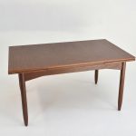 Table à rallonge en teck vintage pour salle à manger ou bureau, avec design épuré et bois de qualité. Parfaite pour accueillir famille ou amis lors de repas ou réunions.