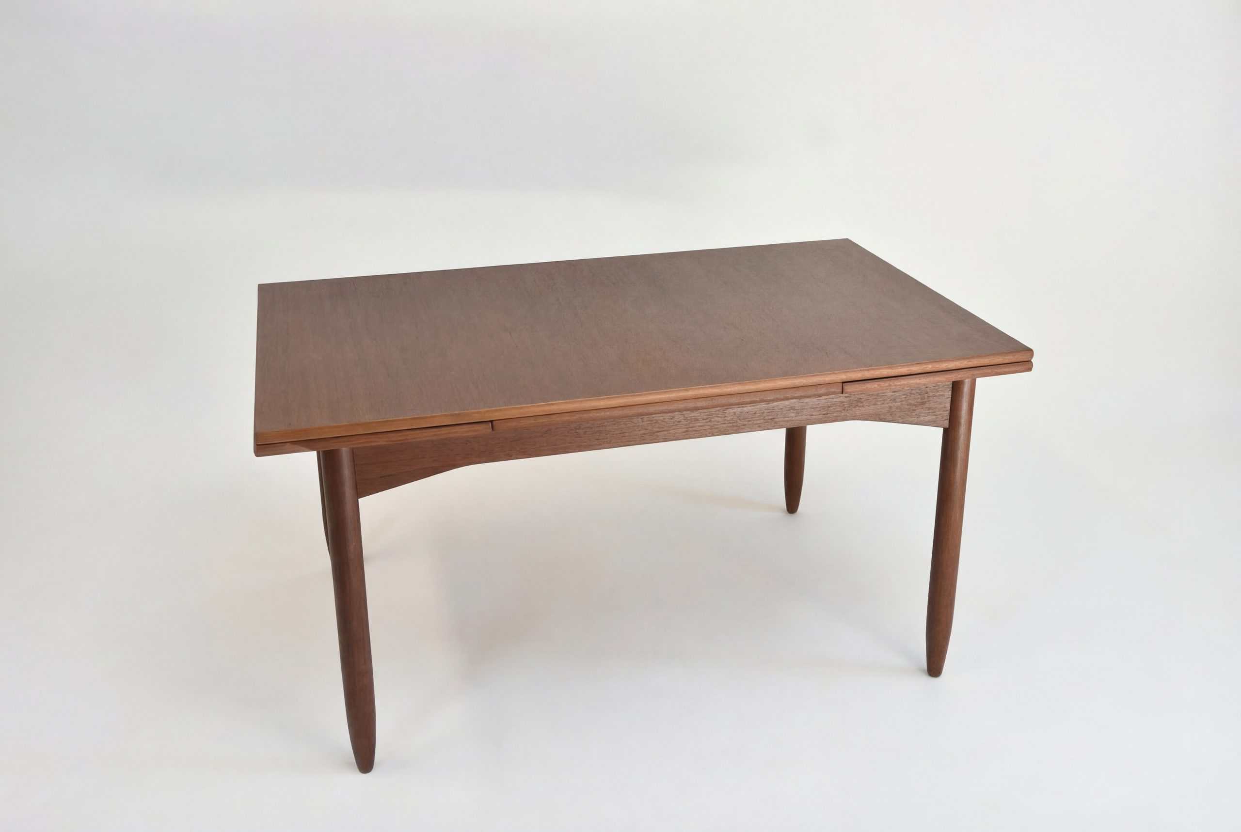 Table à rallonge en teck vintage pour salle à manger ou bureau, avec design épuré et bois de qualité. Parfaite pour accueillir famille ou amis lors de repas ou réunions.